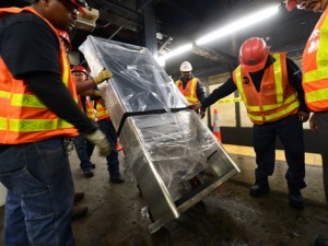 MTA New York City Transit Infrastructure crew installs a new On The Go (OTG) kiosk on the northbound platform at Chambers St on the 7th Av line .